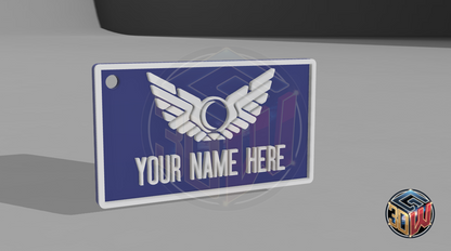 3D-printed, blue and white name tag with a space-themed design, featuring a winged emblem and customizable text area labeled 'Your Name Here.' The tag is rectangular, lightweight, and is a computer render.